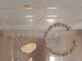 two necklaces and a bracelet on display in a case
