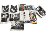 une image représentant une pile de vieilles photos et de cartes postales posées sur une surface blanche