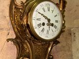 a clock on the wall of a building with a dragon on it