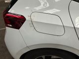 the rear end of a white car parked in a parking lot