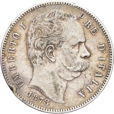 a silver coin with a man ' s face and mustache on it