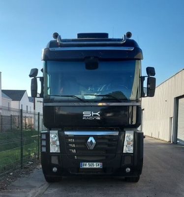 un gros camion noir garé devant un immeuble