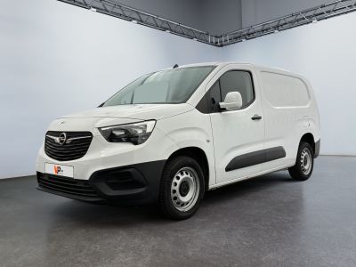 La camionnette blanche est garée dans une grande pièce.