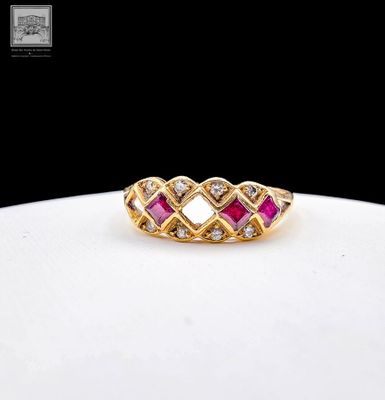 gros plan d'une bague en or avec des pierres roses et blanches