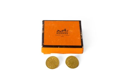 une boîte orange contenant deux pièces d'or posées l'une à côté de l'autre
