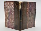 an old book with a pen inside of it sitting on a table