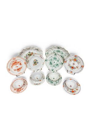 a group of porcelain dishes and cups on a white surface