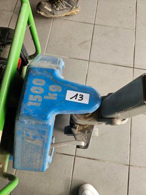 un cyclomoteur bleu et vert posé par terre à côté d'une personne