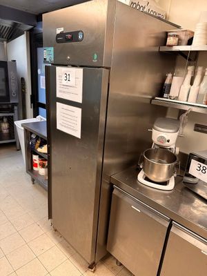 a large stainless steel refrigerator in a kitchen with shelves