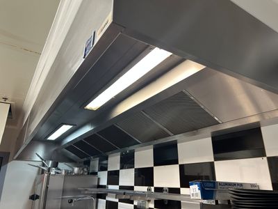 une cuisine équipée d'une cuisinière, d'un four et de plans de travail à carreaux