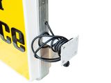 a close up of a yellow sign with a black cord attached to it