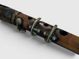 a wooden flute with a metal handle on a white surface