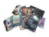une pile de CD de toutes sortes posée sur une surface blanche