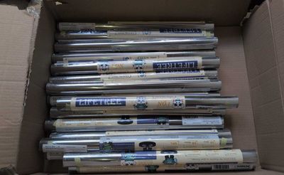 plusieurs rouleaux de papier d'argent dans une boîte en carton posée sur une table