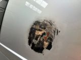 a hole in the side of a car that has a picture of a person on it