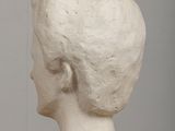 plaster head of a woman on a table with a gray background