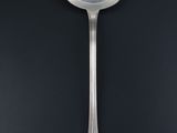 silver spoon on a black surface with a black background
