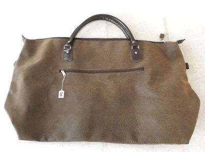 un sac à main en cuir marron, orné d'une étiquette, posé sur une surface blanche
