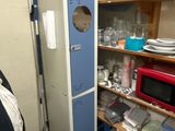 a refrigerator in the corner of a room with a lot of clutter on the floor