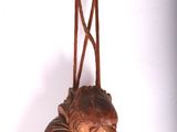 a wooden bird hanging on a string on a white wall