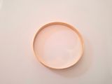 a white bowl with a wooden rim on a white surface