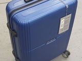 a blue suitcase sitting on the sidewalk with a tag attached to it