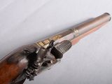 an old gun with a wooden handle on a white surface