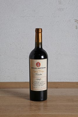 a bottle of red wine sitting on a wooden table