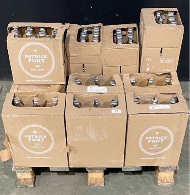 Des caisses de bière sont empilées sur une palette devant un mur noir