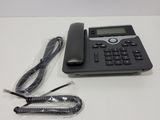 an image of a corded telephone with a cord and a charger on a table