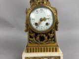 une horloge en or surmontée d'un oiseau