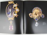 an open book with a picture of a gold broochle and a diamond broochle