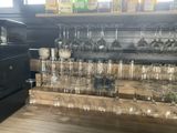 a wooden shelf with wine glasses and bottles on it