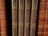five books on a shelf in a book case