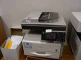 une imprimante posée sur un bureau, à côté d'une boîte