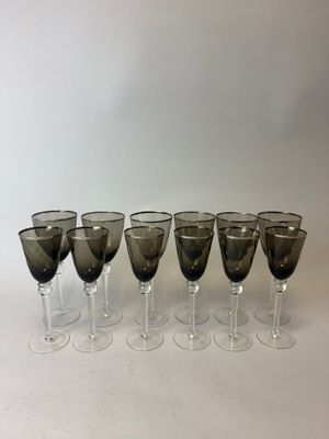 six verres à vin sont alignés sur une surface blanche