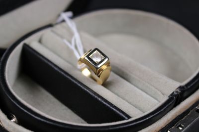 a gold ring with a black stone in it in a case