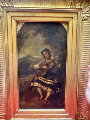 un tableau représentant une femme jouant de la guitare, dans un cadre doré