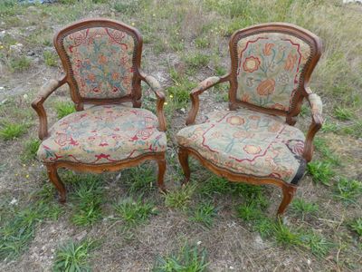 une paire de chaises rembourrées anciennes au milieu d'un champ d'herbe