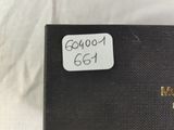 an old black box with a label on it sitting on a bed