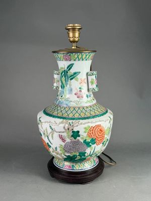 un vase blanc orné de fleurs, posé sur un socle en bois