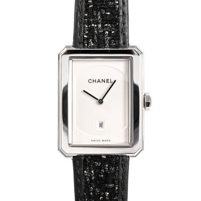 un gros plan d'une montre avec un bracelet noir sur fond blanc
