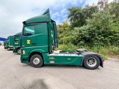 a green semi truck that is parked in a lot