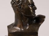 a bronze bust of a man with curly hair on a marble base