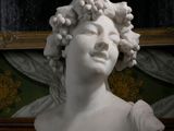 un buste de femme aux cheveux bouclés posé sur une table