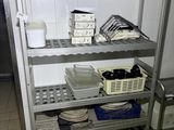 a metal shelf with dishes on it in a kitchen
