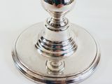 a silver candle that is sitting on a white table