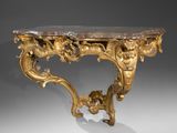 une table console ornementale sculptée avec un plateau en marbre