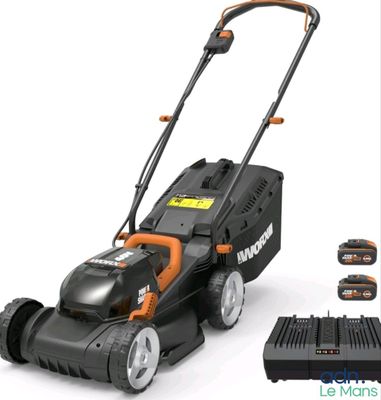 une tondeuse à gazon électrique Black & Decker avec ses batteries et son chargeur