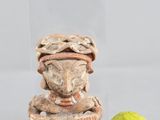 une figurine posée à côté d'une poire sur une table